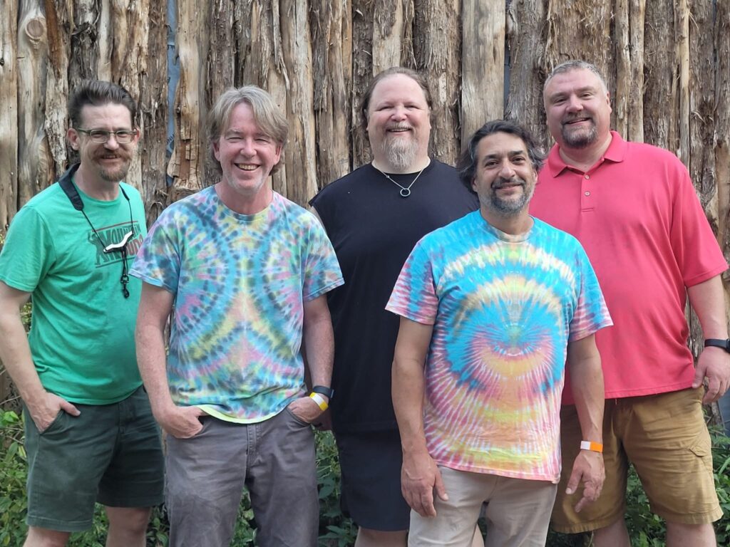The five members of Zentrance standing in front of a wooden fence